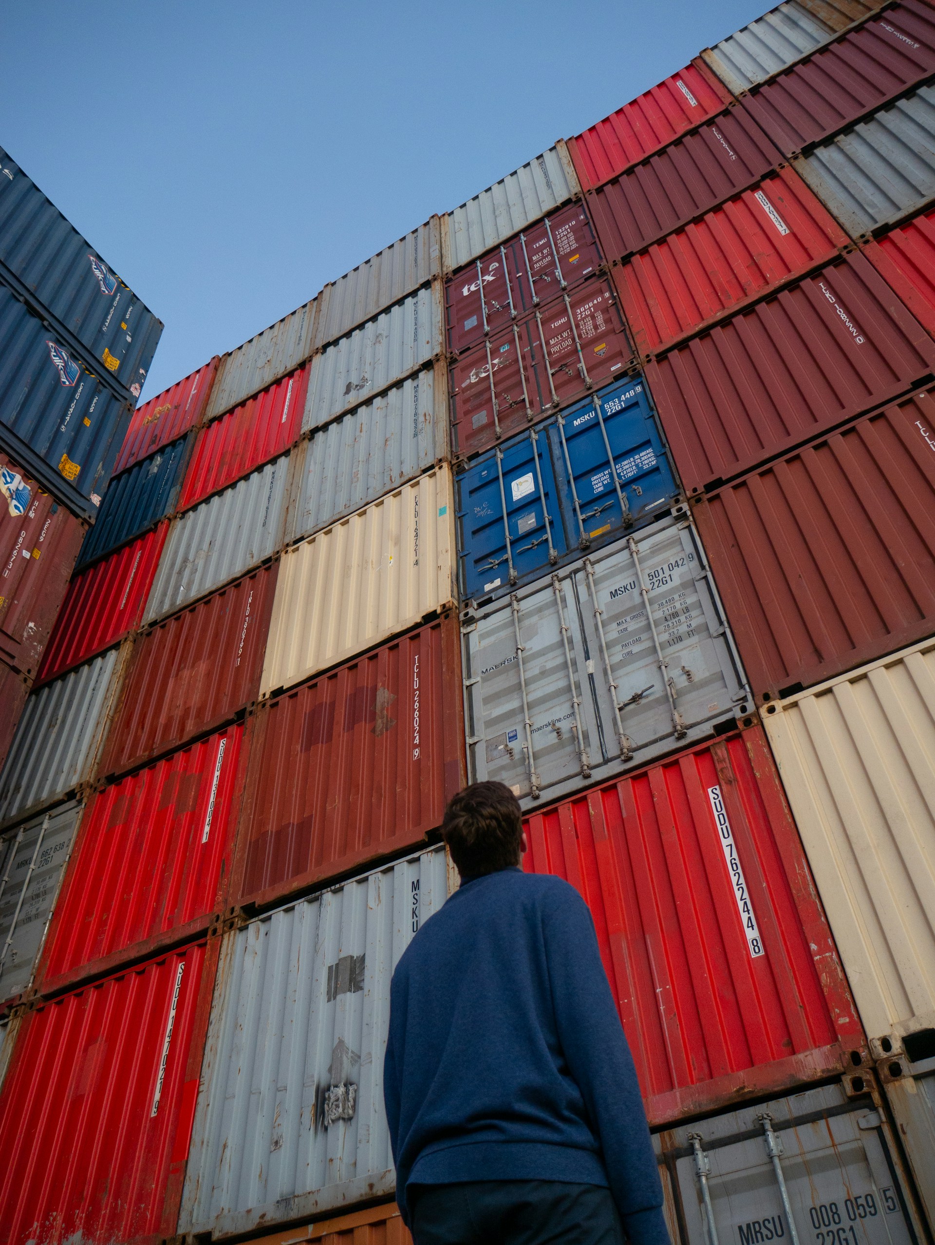 A man standing in front of containers